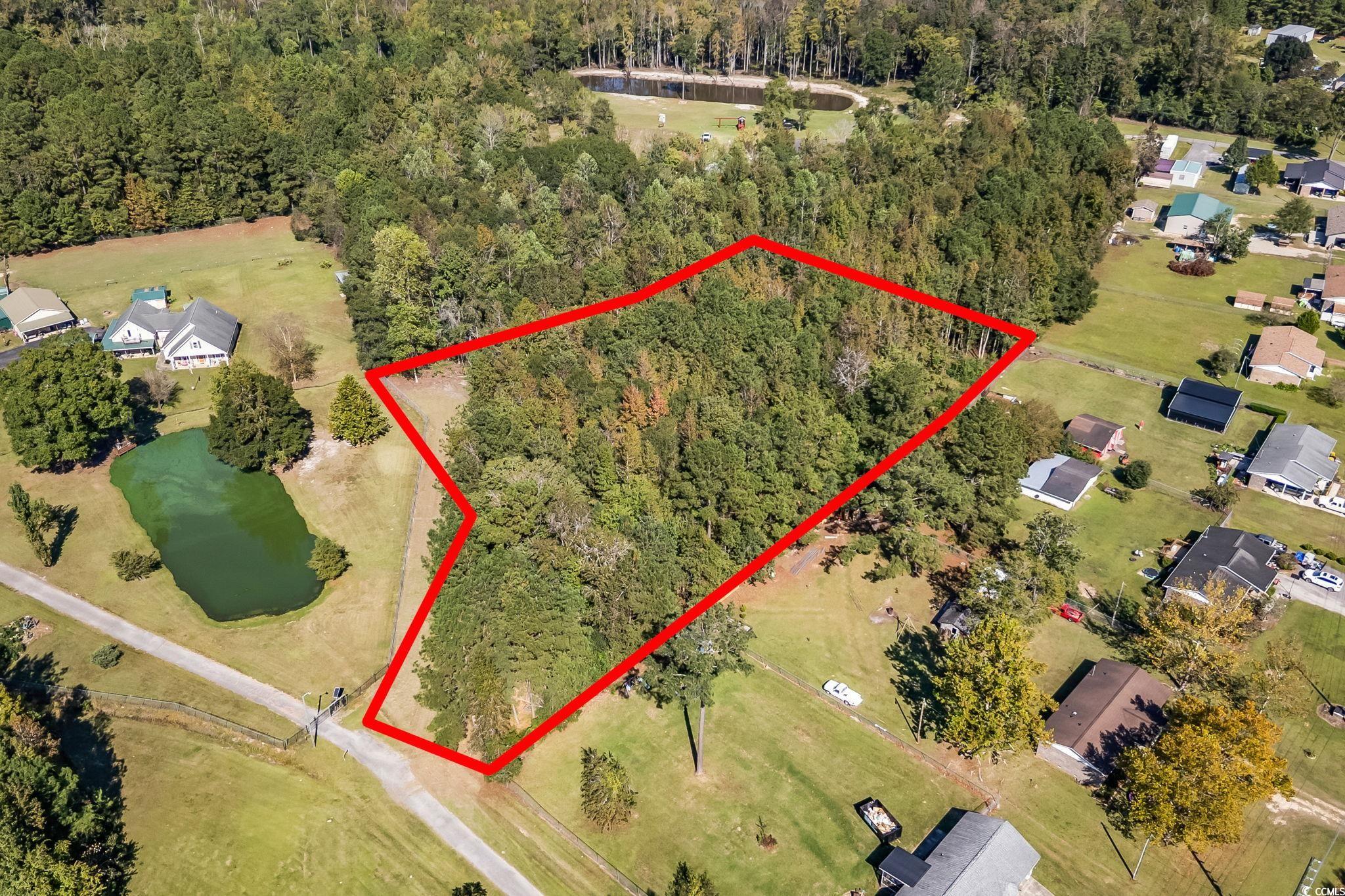 Aerial view of residential area featuring a nearby body of water and property parcel outlined