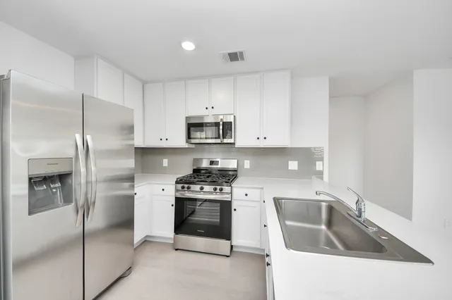 a view of a kitchen with a sink and cabinets