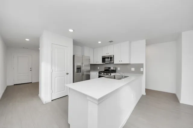 a kitchen with stainless steel appliances a sink stove and refrigerator