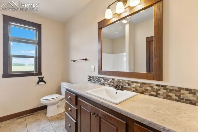 an empty room with chandelier fan and windows