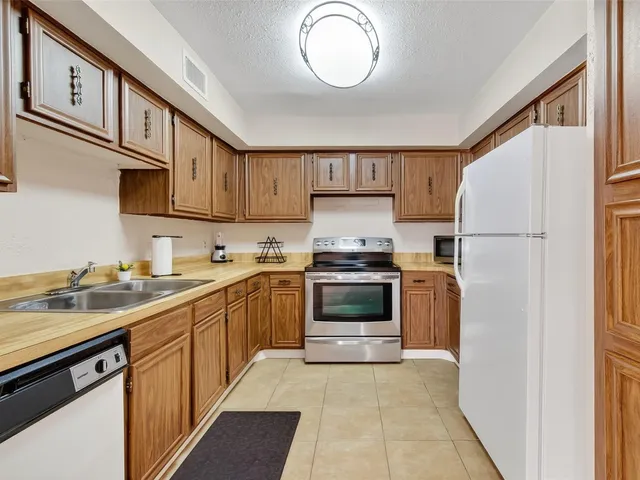 an empty room with chandelier fan and windows
