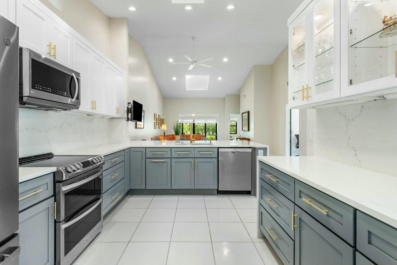 8211 Springlake Drive Boca Raton, FL 33496 - Photo 8 of 49 a kitchen with a sink stainless steel appliances and cabinets