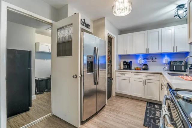 a kitchen with stainless steel appliances granite countertop a refrigerator a stove and a sink