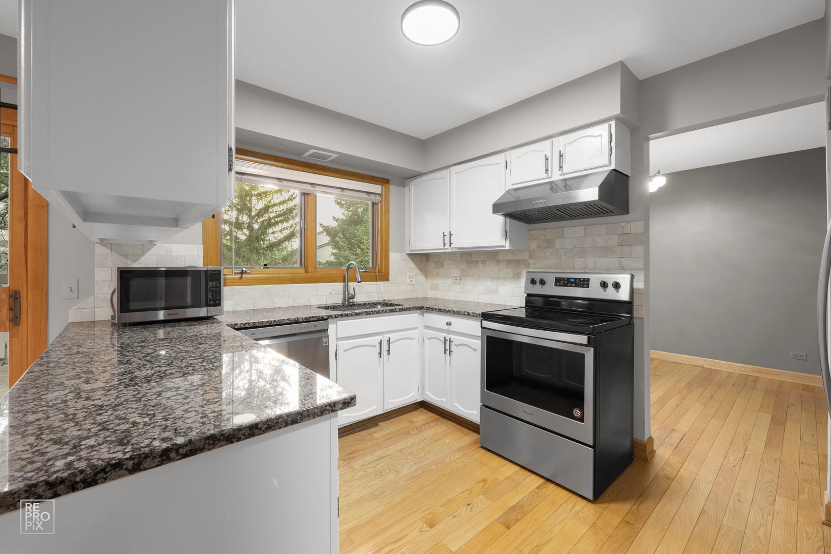 2627 Smith Street Rolling Meadows, IL 60008 - Photo 9 of 23 a kitchen with stainless steel appliances granite countertop a stove a sink and a microwave