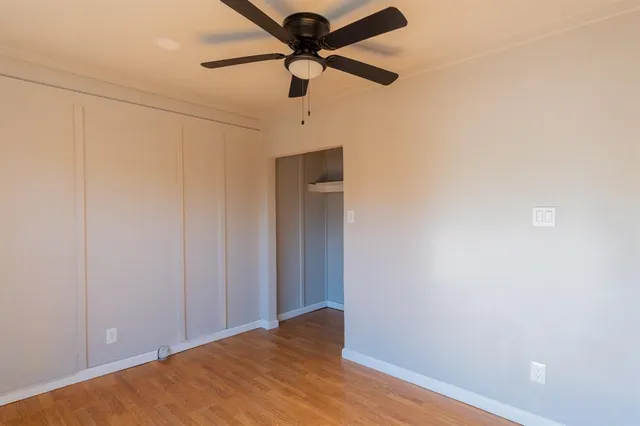 a view of a livingroom with a ceiling fan and wooden floor