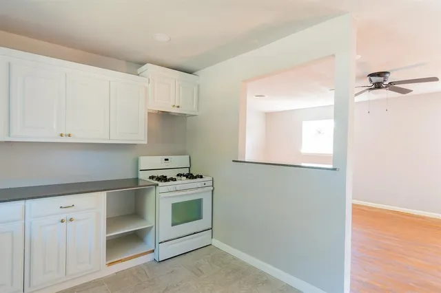 a kitchen with white cabinets and white appliances