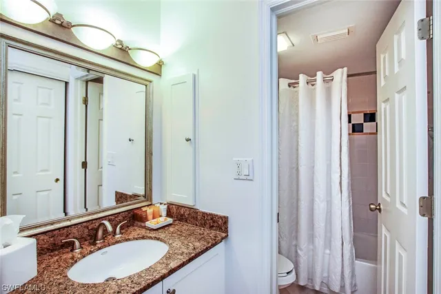 a bathroom with a toilet and a shower curtain