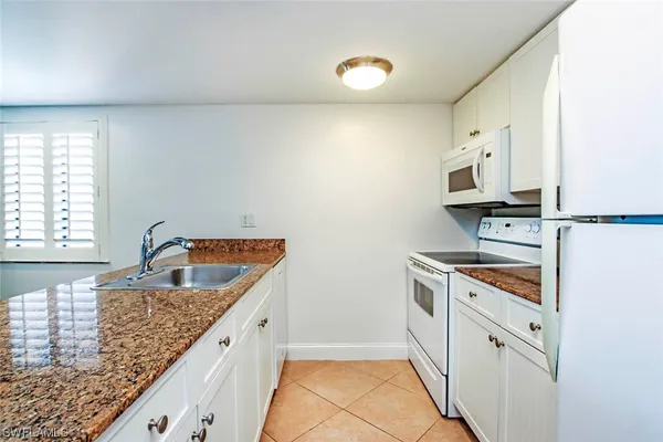 a kitchen with a refrigerator sink and cabinets