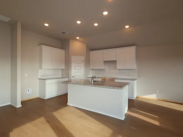 a kitchen with white cabinets and sink