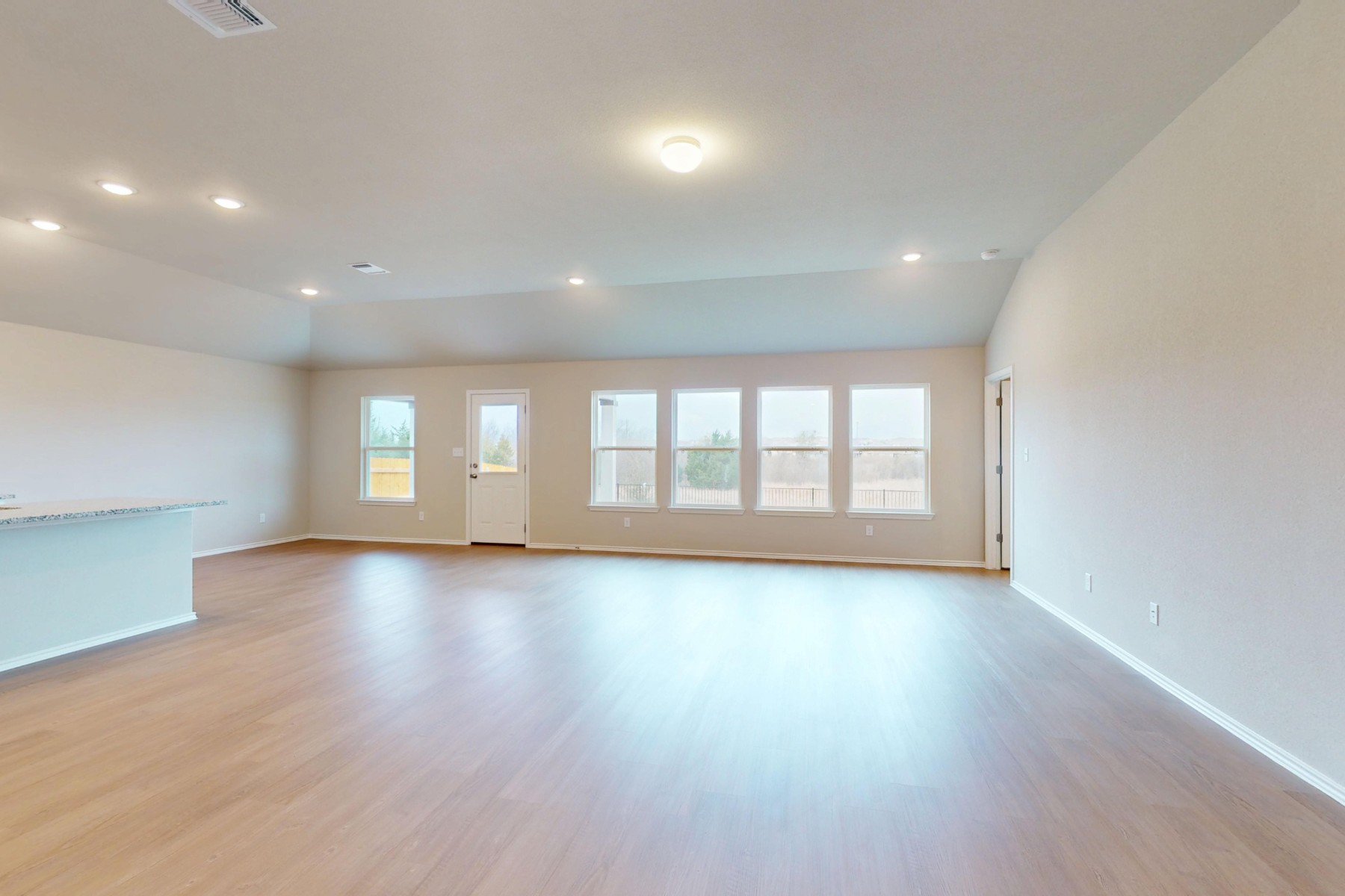 19917 Schatz Way Manor, TX 78653 - Photo 2 of 33 an empty room with wooden floor and windows