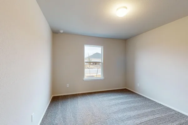 a view of an empty room with a window and closet area