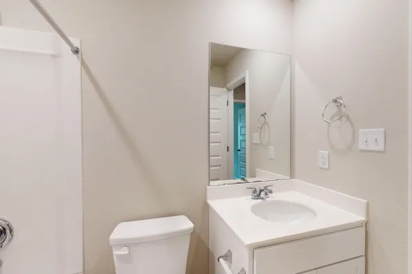 a bathroom with a toilet a sink and a mirror