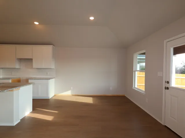 a kitchen with a white cabinets and window