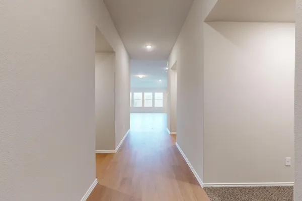 a view of a hallway with wooden floor