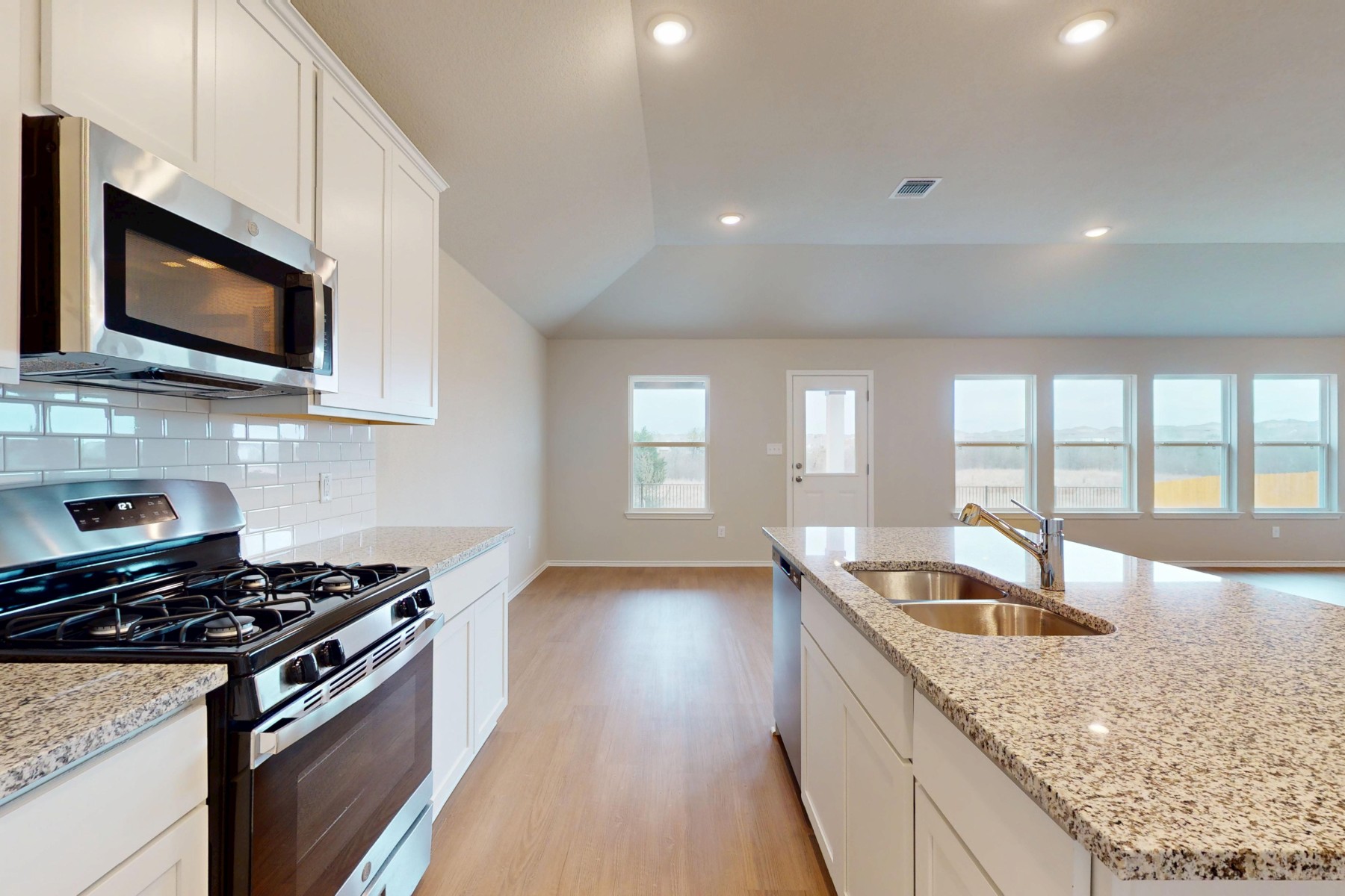 19917 Schatz Way Manor, TX 78653 - Photo 8 of 33 a kitchen with granite countertop a sink and a stove top oven