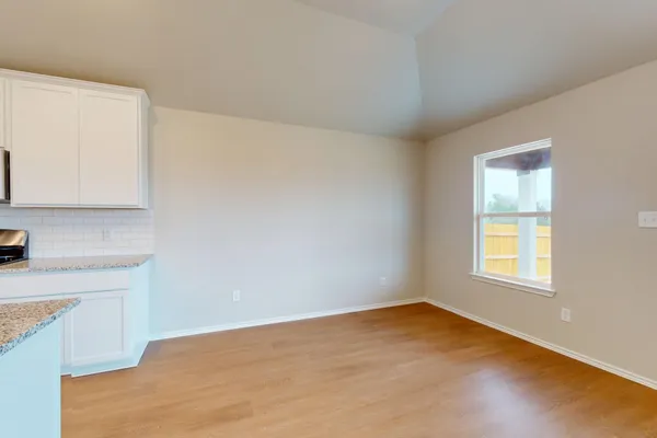 a view of a kitchen with wooden floor and a window
