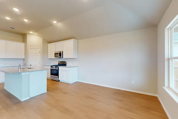 a kitchen with white cabinets and appliances