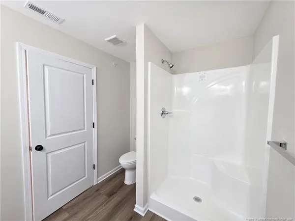 a bathroom with a shower a toilet and sink