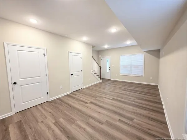an empty room with wooden floor and cabinet