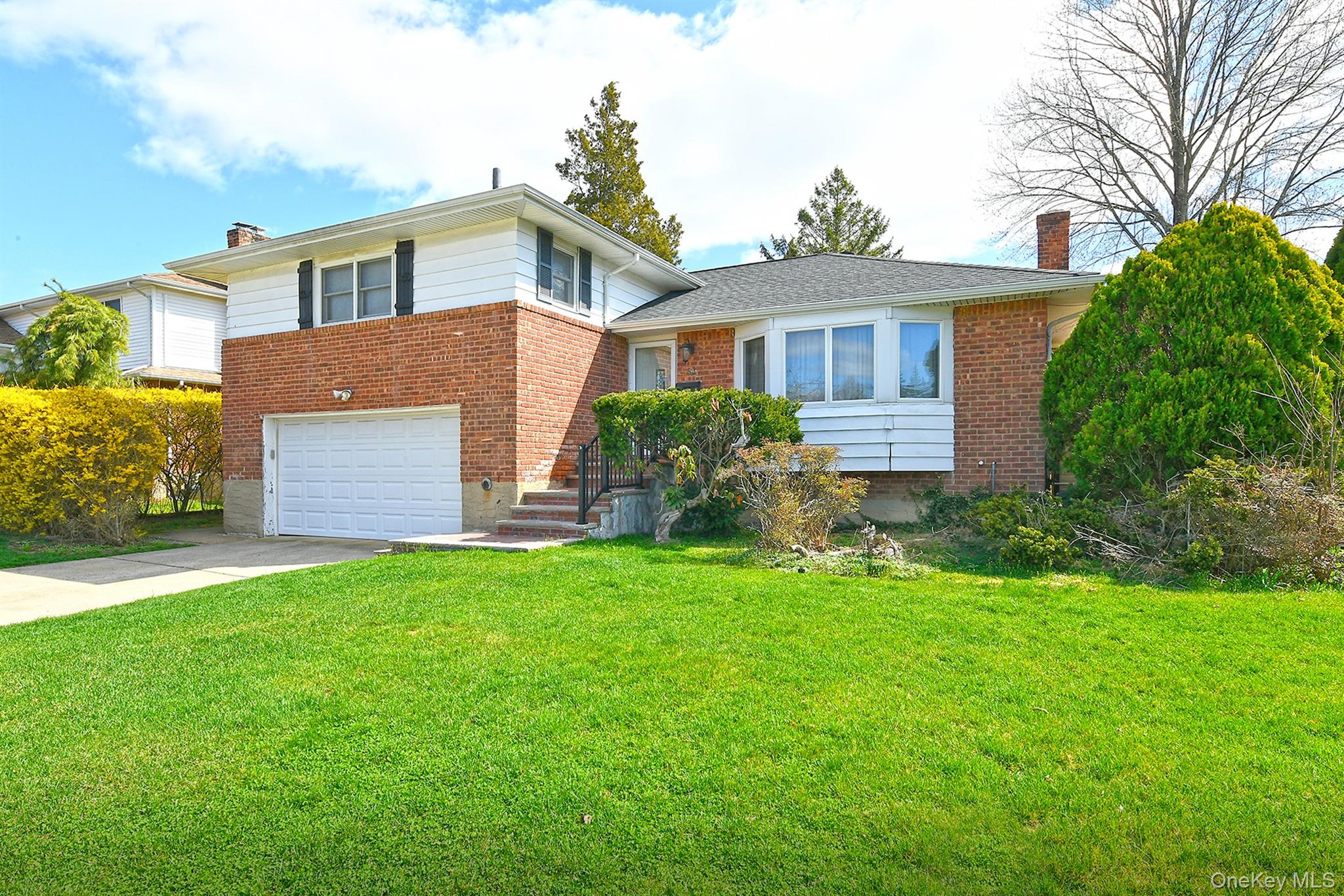 53 Stuart Drive Syosset, NY 11791 - Photo 2 of 24 a front view of a house with a yard and garage