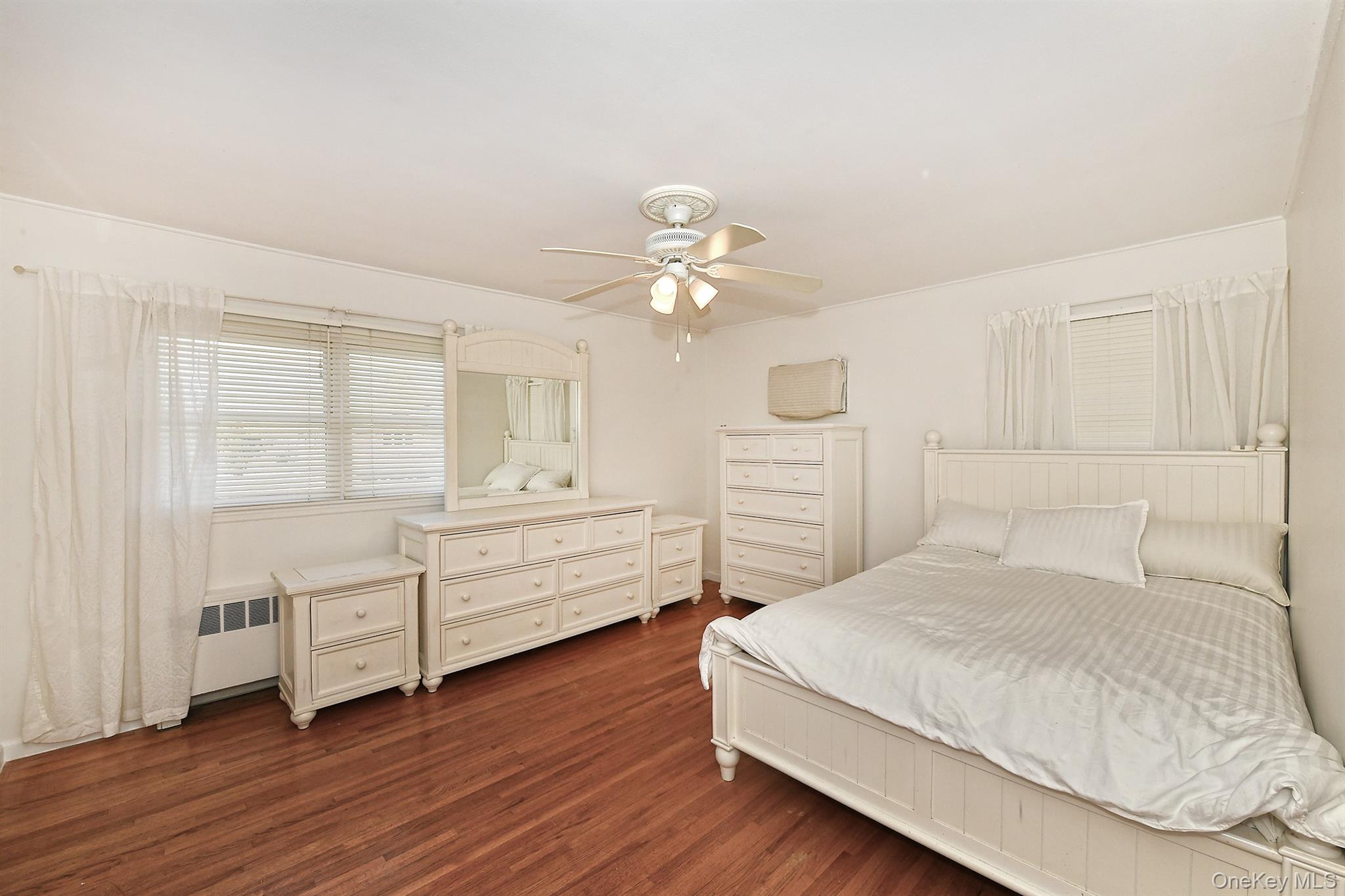 53 Stuart Drive Syosset, NY 11791 - Photo 8 of 24 a bedroom with a bed and a chandelier