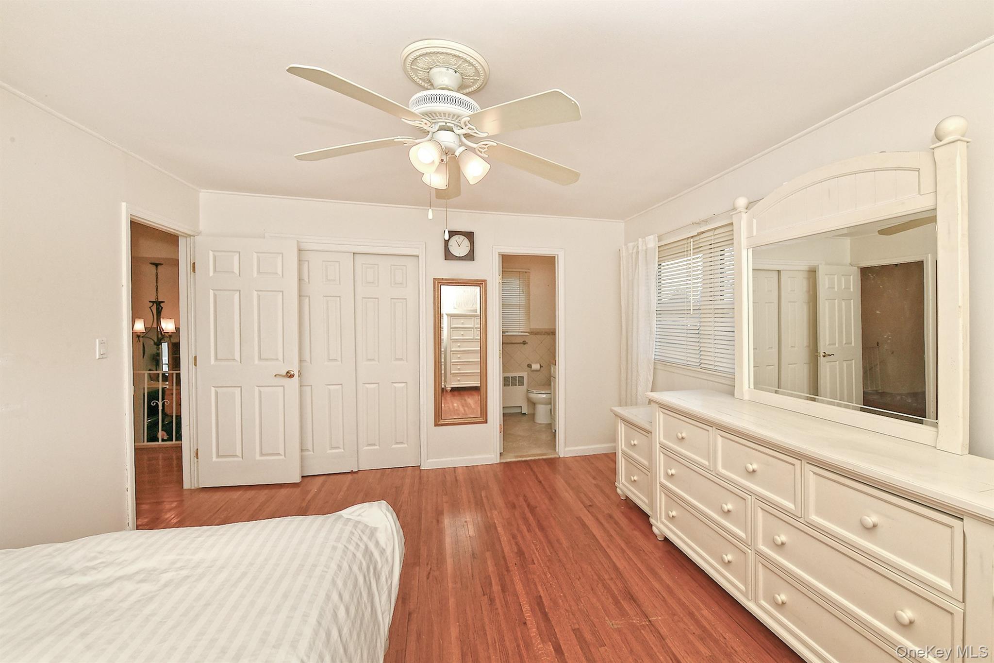 53 Stuart Drive Syosset, NY 11791 - Photo 9 of 24 a bedroom with a large bed and a chandelier