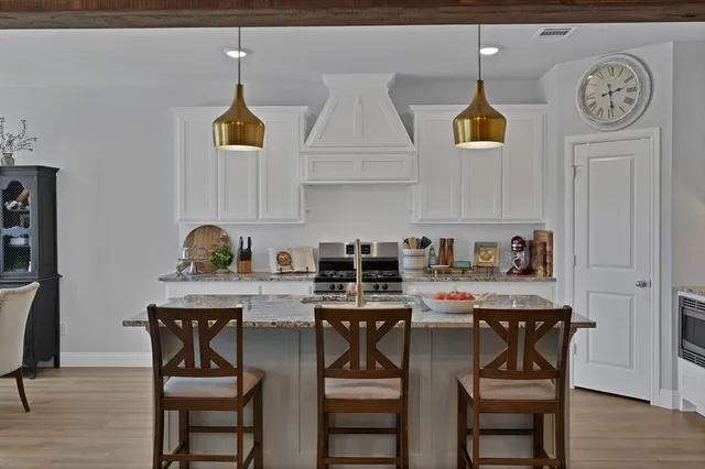 a kitchen with stainless steel appliances a table chairs and a refrigerator