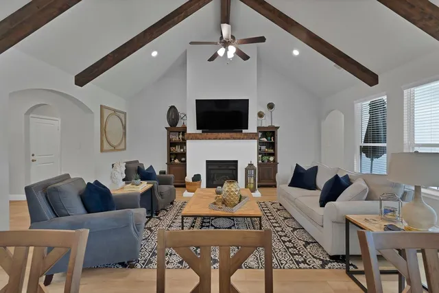 a living room with furniture a flat screen tv and a fireplace