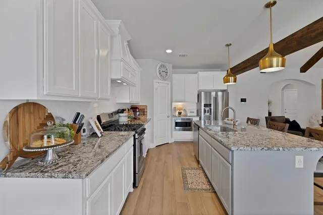 a kitchen with sink stove and cabinets