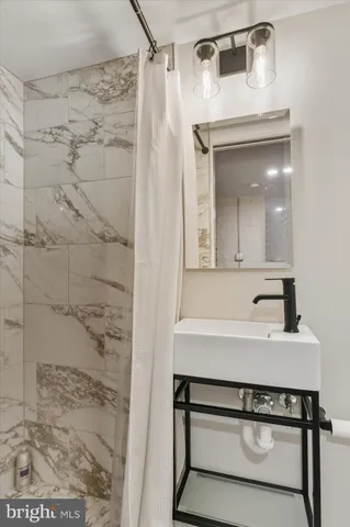 a bathroom with a sink a mirror and shower