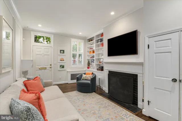 a living room with furniture a flat screen tv and a fireplace