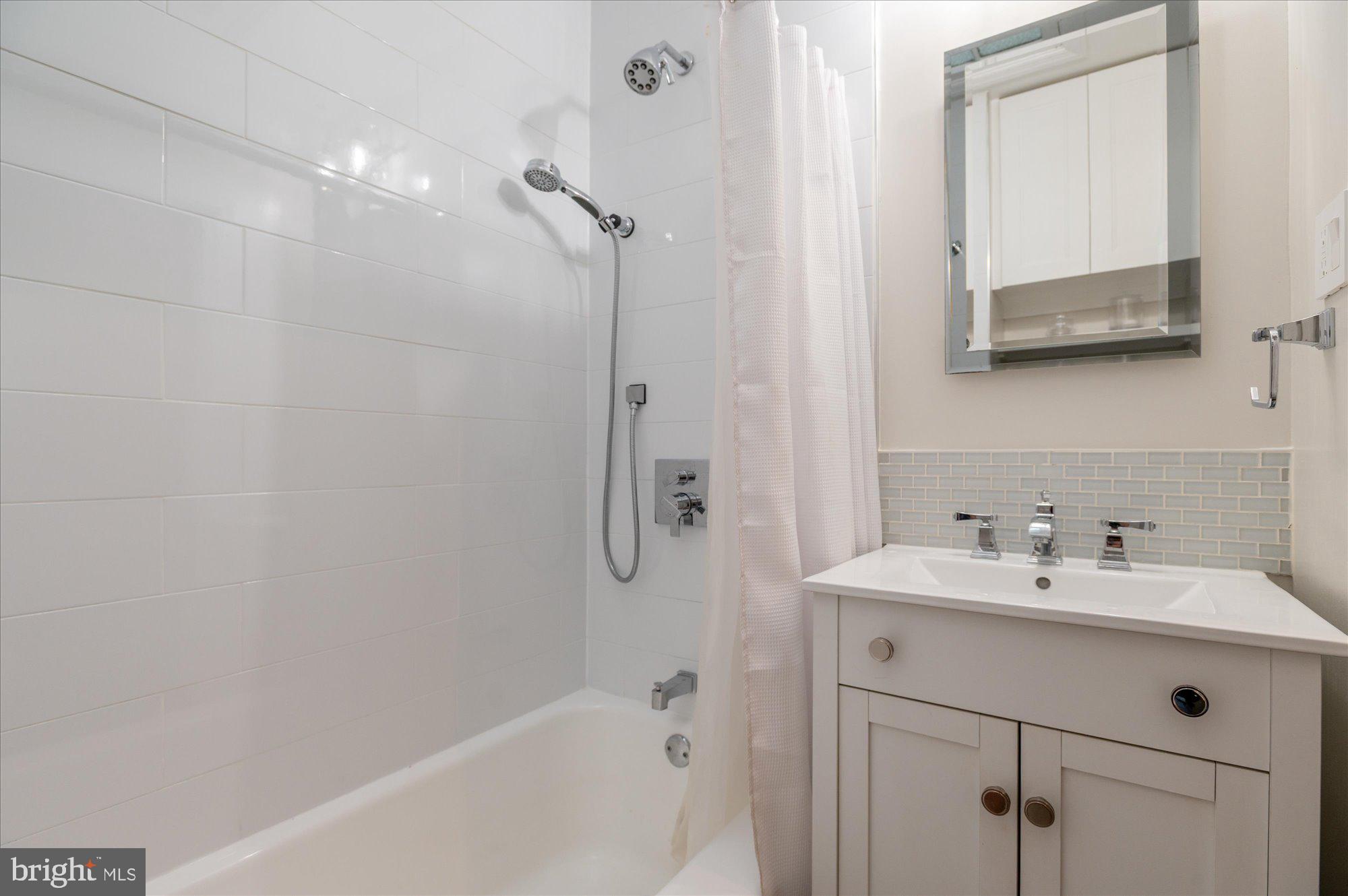 1341 28th Street Northwest Washington, DC 20007 - Photo 10 of 17 a bathroom with a sink a mirror and a bathtub