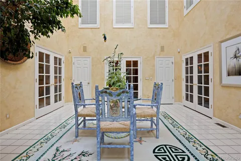 a living room with furniture large windows and wooden floor