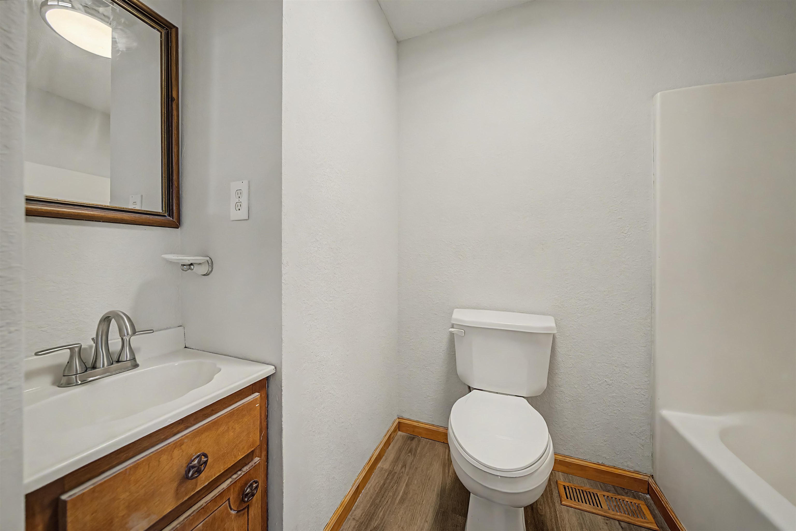 2380 Dunaway Road Selmer, TN 38375 - Photo 22 of 39 Bathroom featuring a white bathtub, toilet, and a vanity with a white countertop and wood-finish cabinetry