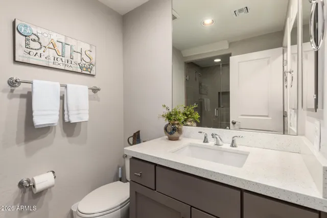a bathroom with a sink vanity mirror and toilet