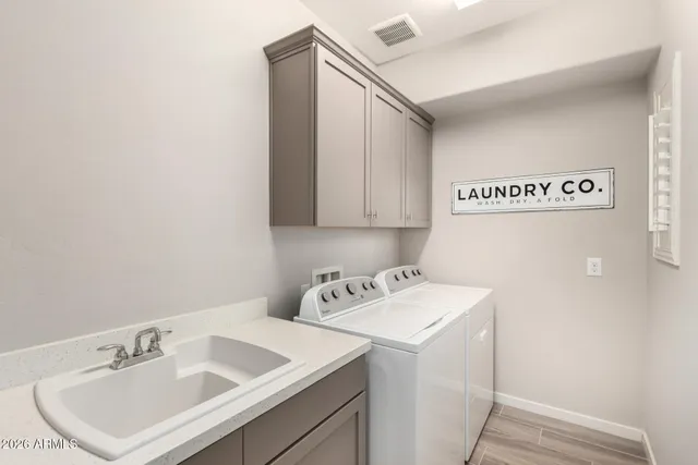 a utility room with sink dryer and washer