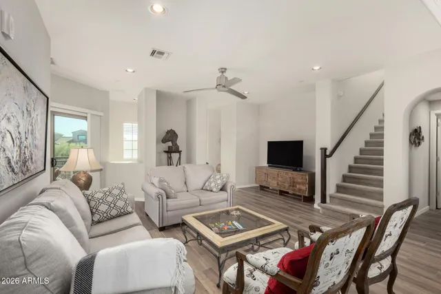 a living room with furniture a flat screen tv and a table