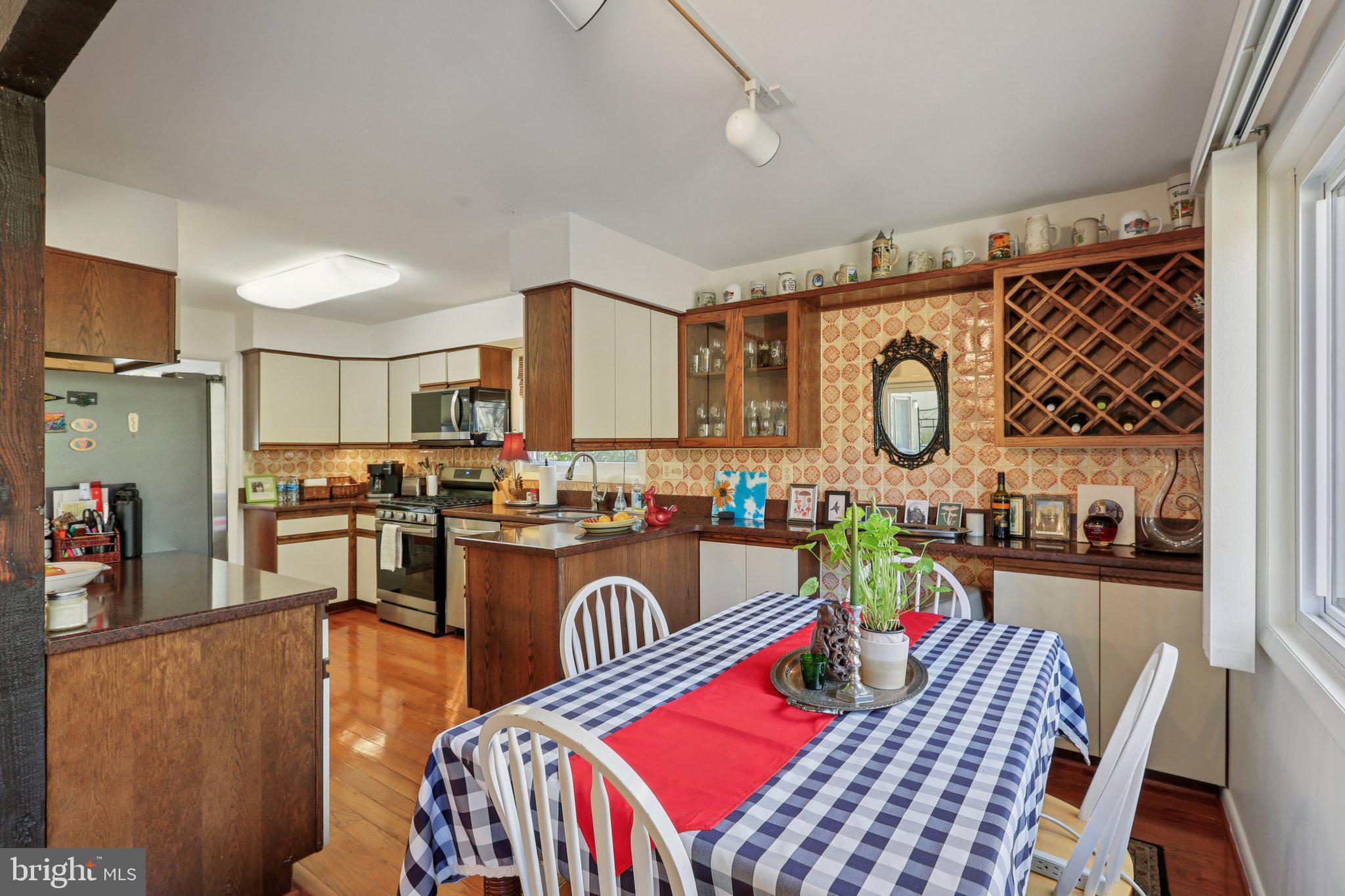 10968 Swansfield Road Columbia, MD 21044 - Photo 18 of 57 a view of a dining room and kitchen with a table chairs a workspace