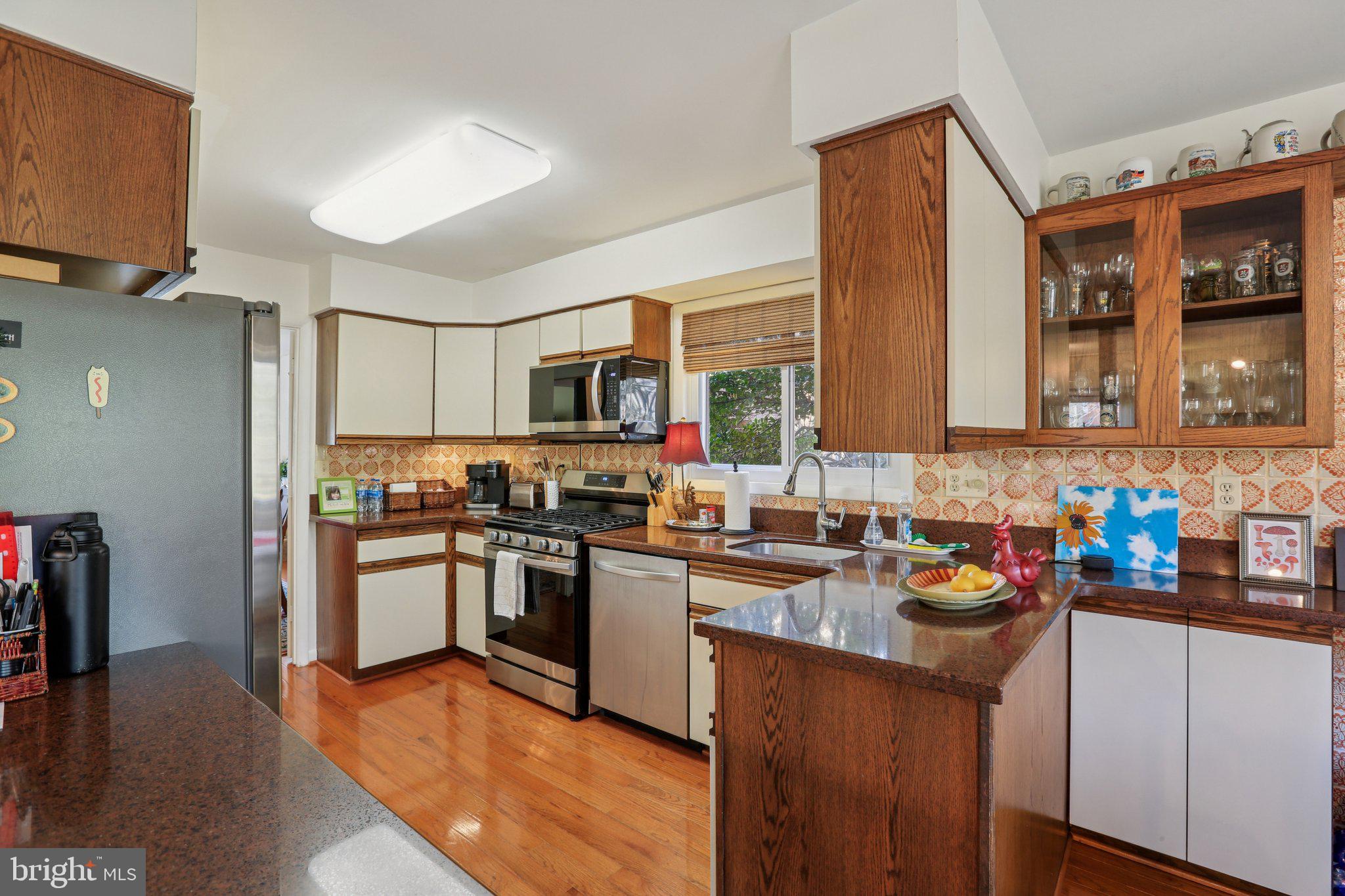 10968 Swansfield Road Columbia, MD 21044 - Photo 20 of 57 a kitchen with stainless steel appliances granite countertop a sink stove and refrigerator