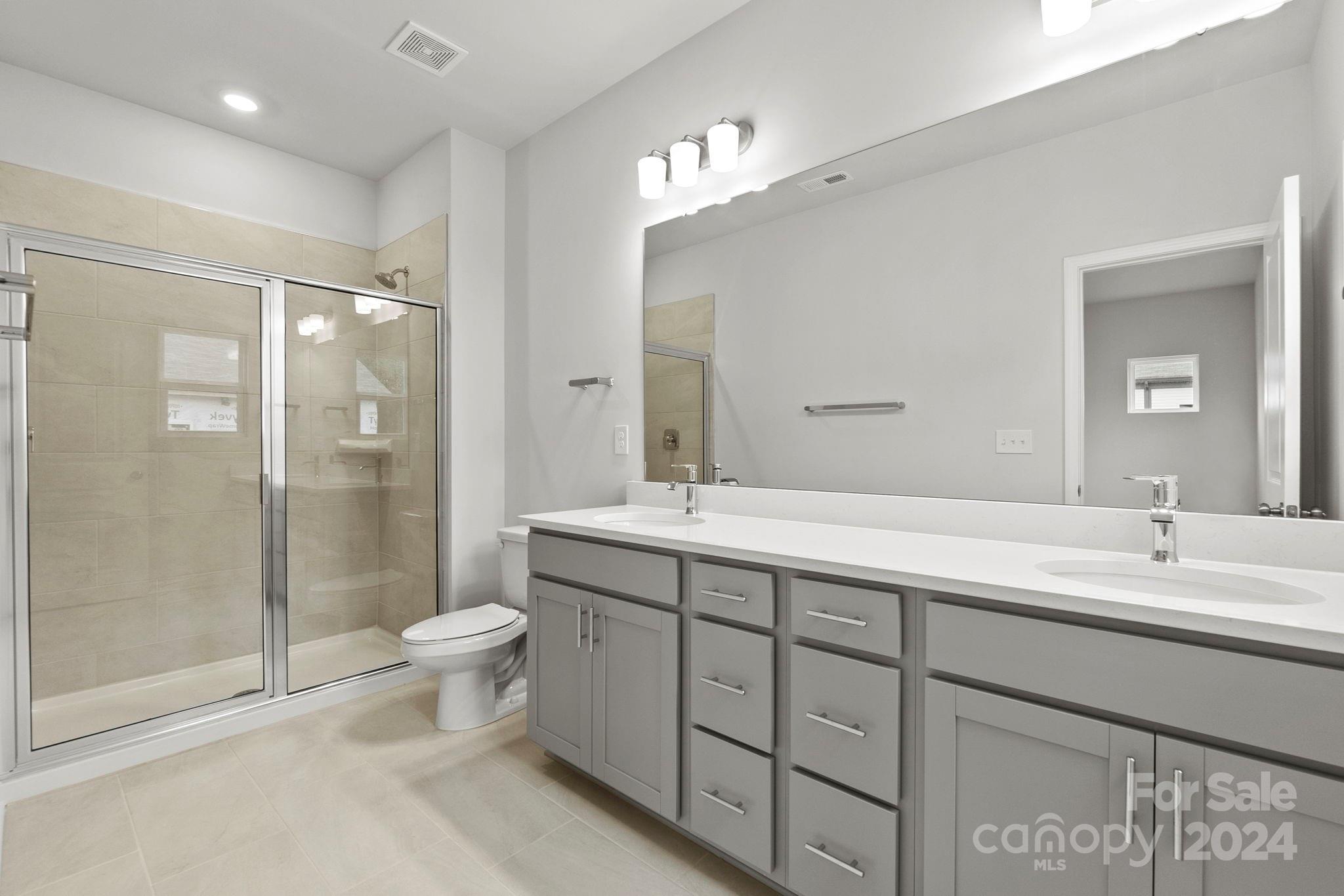 1702 Blanche Street Albemarle, NC 28001 - Photo 13 of 29 a spacious bathroom with a double vanity sink toilet mirror and shower