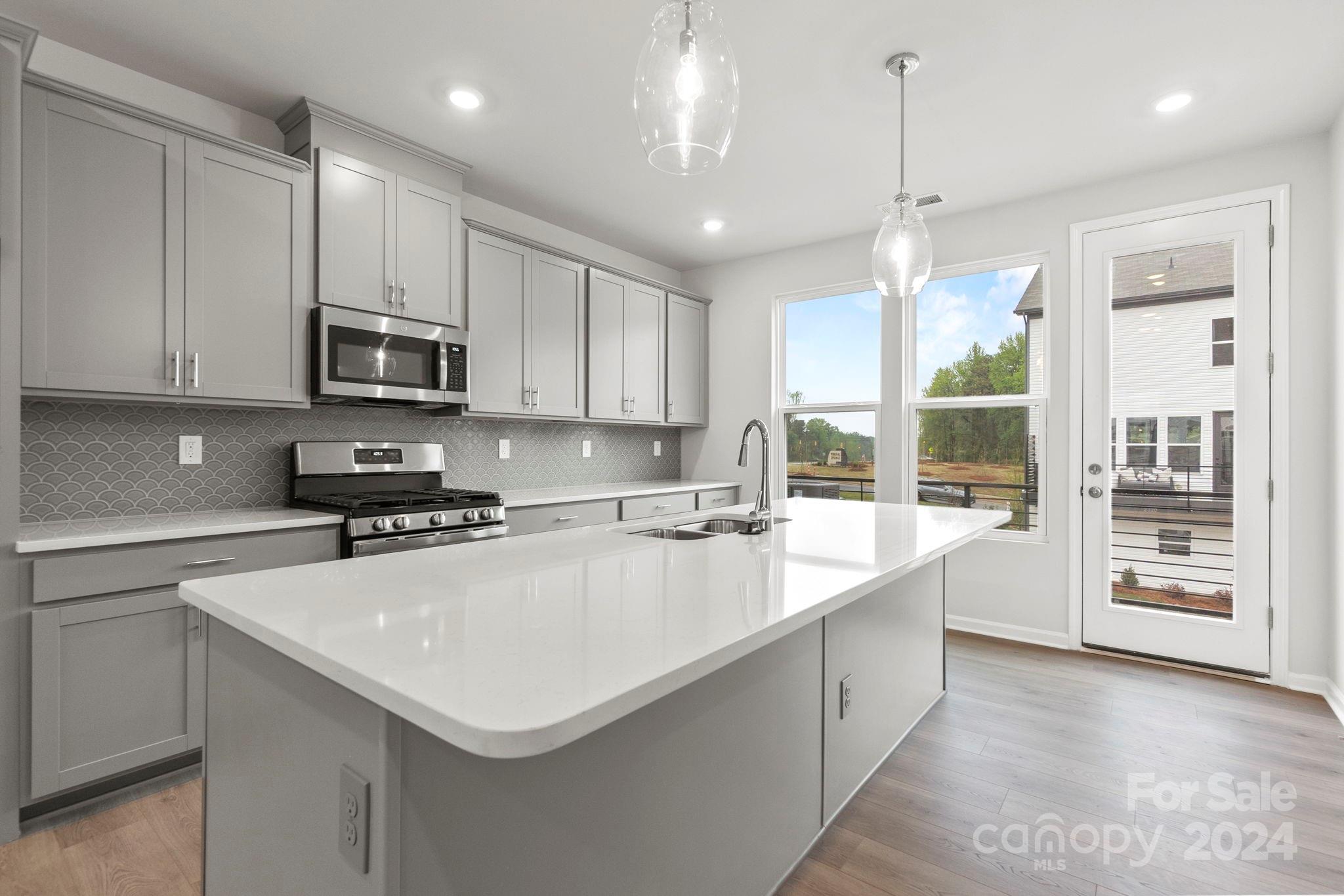 1702 Blanche Street Albemarle, NC 28001 - Photo 27 of 29 a large kitchen with kitchen island a sink stainless steel appliances and cabinets