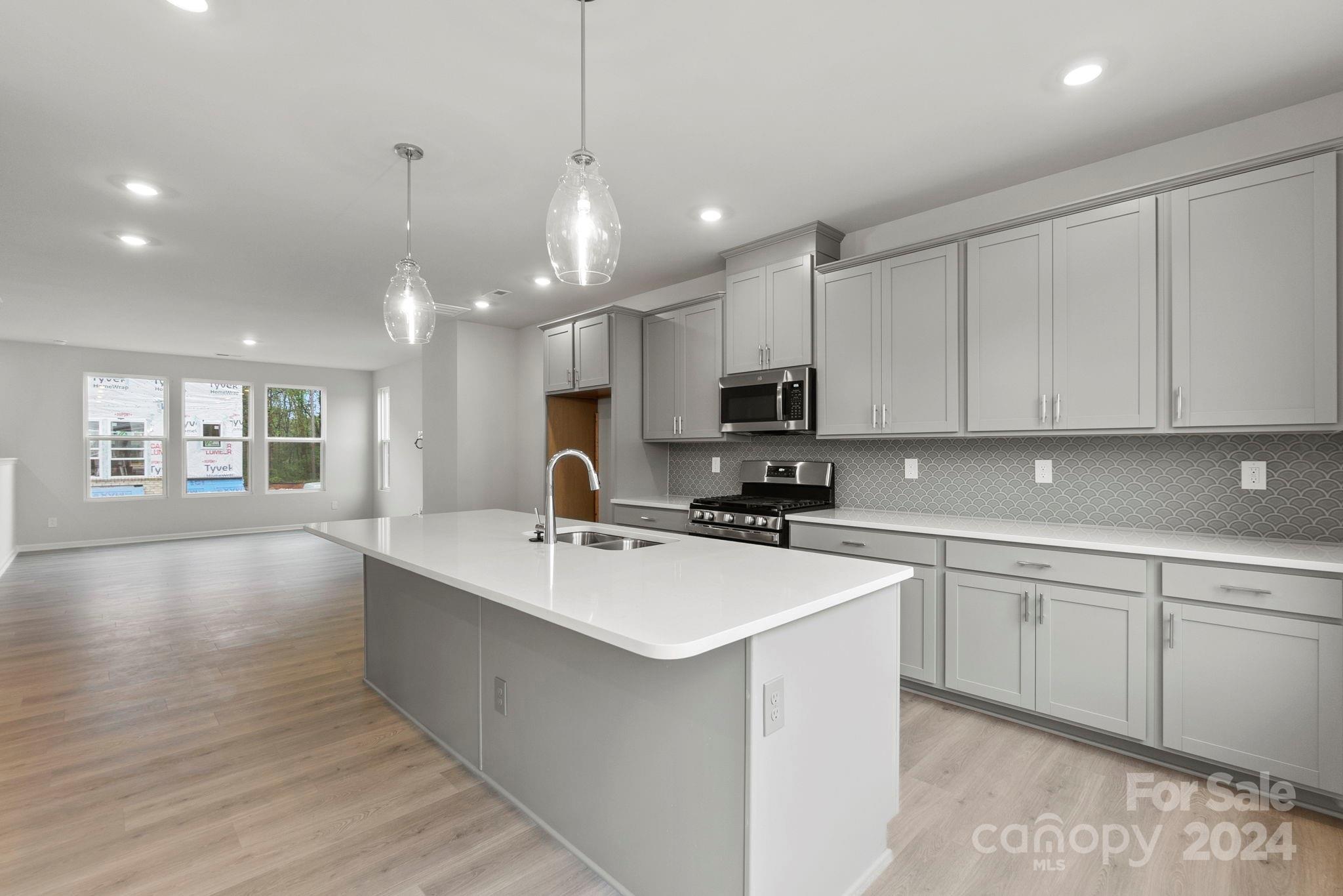1702 Blanche Street Albemarle, NC 28001 - Photo 28 of 29 a kitchen with stainless steel appliances a sink a stove a refrigerator cabinets and wooden floor