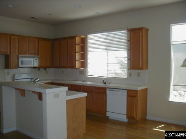 1134 University Ridge Drive Reno, NV 89512 - Photo 4 of 9 a kitchen with a sink stove and cabinets