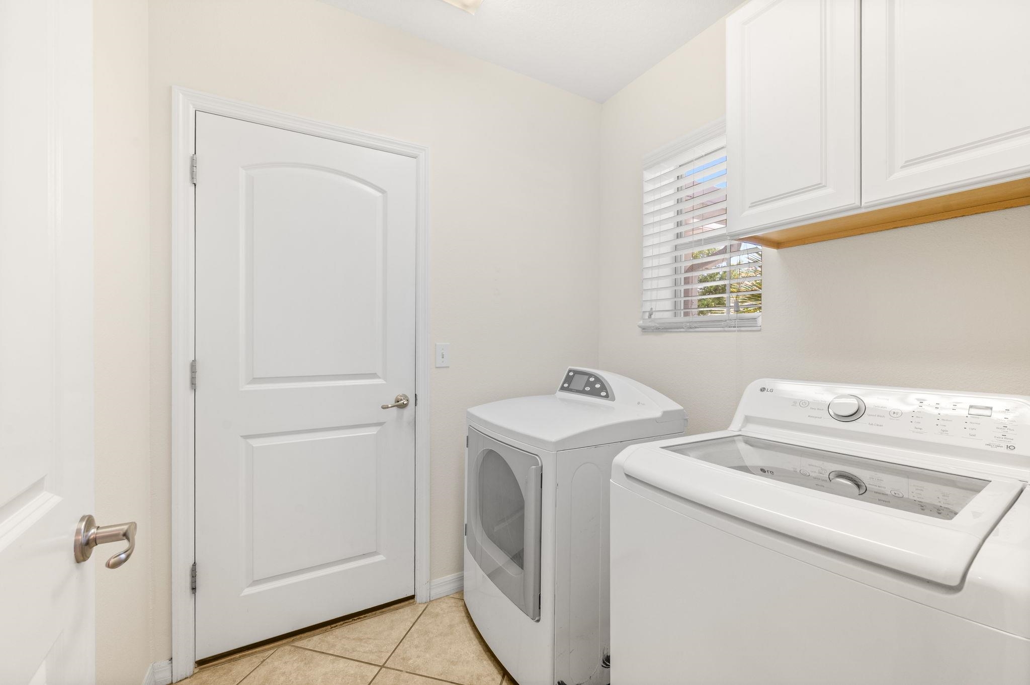 1184 Overdale Road St. Augustine, FL 32080 - Photo 6 of 75 Laundry area with cabinet space, washer and dryer, and light tile patterned flooring