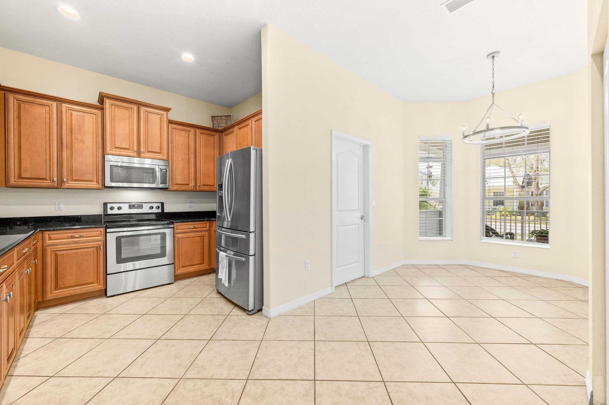 1184 Overdale Road St. Augustine, FL 32080 - Photo 7 of 75 Kitchen with stainless steel appliances, wood finish cabinetry, dark stone countertops, and light tile patterned floors