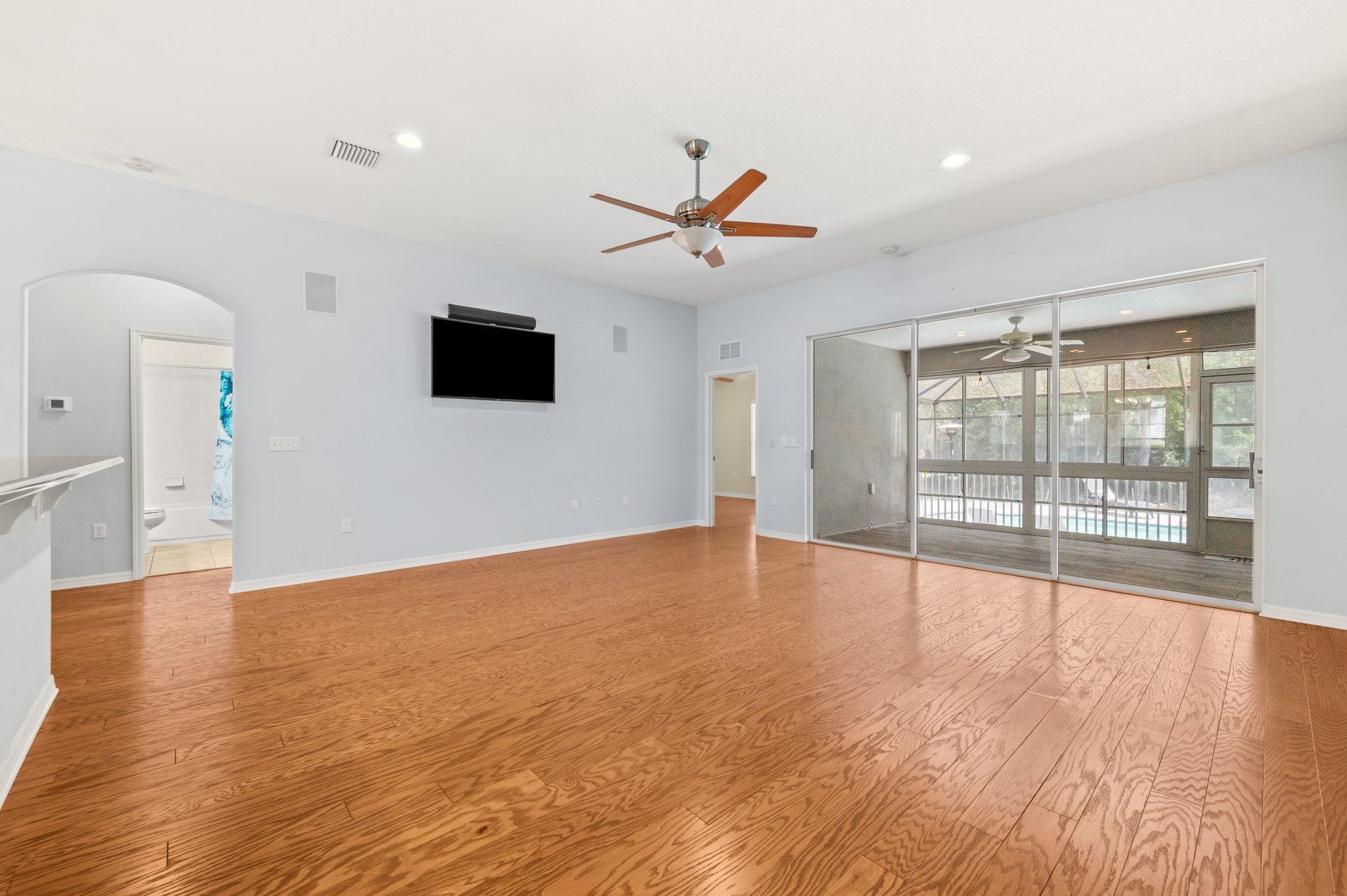 1184 Overdale Road St. Augustine, FL 32080 - Photo 9 of 75 Unfurnished living room with arched walkways, light wood finished floors, a ceiling fan, and recessed lighting