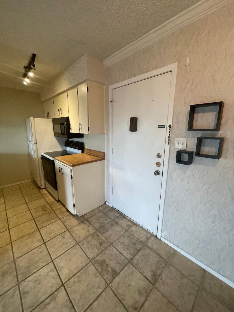 910 Duncan Lane, Unit 44 Austin, TX 78705 - Photo 3 of 15 Functional kitchen space offers essential appliances and durable tile flooring for everyday living.