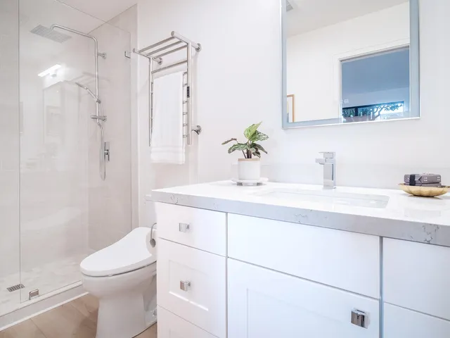 a bathroom with a granite countertop sink a toilet and shower