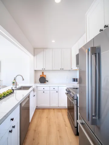 a kitchen with a sink appliances and cabinets