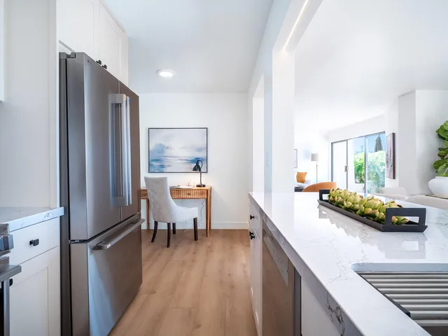 a kitchen with stainless steel appliances granite countertop refrigerator sink and chairs